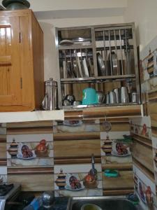 a kitchen with a sink and plates of food at Apple Zone Home stay in Banjār +10 photos