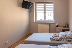 a bedroom with two beds and a window at Noclegi GCK Biała in Biała +30 photos