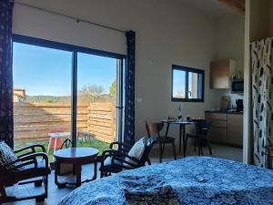 a room with a bed and chairs and a large window at Gite avec piscine in Crespian