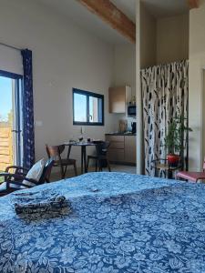 a bedroom with a blue bed and a table and chairs at Gite avec piscine in Crespian