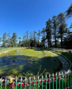 a large pond in a park with a fence at Apple Zone Home stay in Banjār