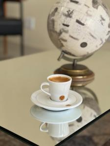 a cup of coffee sitting on a glass table at Seleto Hotel Fazenda in Arrozal +31 photos