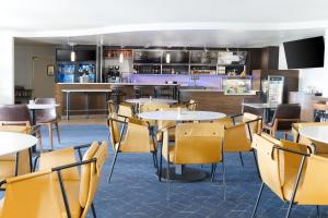 a restaurant with tables and chairs and a bar at Courtyard by Marriott Ontario Rancho Cucamonga in Rancho Cucamonga