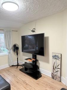 a living room with a large flat screen tv on a wall at Cozy Duplex 2nd floor suite in Winnipeg