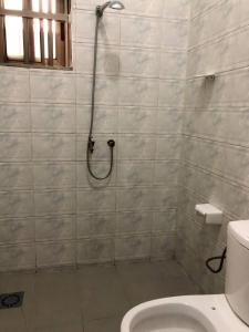 a bathroom with a shower and a toilet at Mariagletta Cozy Villa in Abomey-Calavi +15 photos