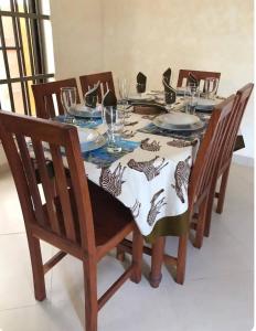 a dining room table with chairs and a table cloth on it at Mariagletta Cozy Villa in Abomey-Calavi