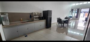 a kitchen with a refrigerator and a table with chairs at Spacious 4 bedroom homestay in Mersing