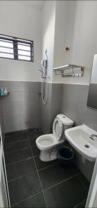 a bathroom with a toilet and a sink at Spacious 4 bedroom homestay in Mersing