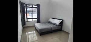 a small bed in a room with a window at Spacious 4 bedroom homestay in Mersing
