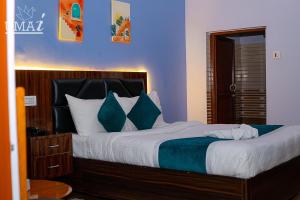 a bedroom with a large bed with blue walls at Umai Garden Resort in Jogīkuti