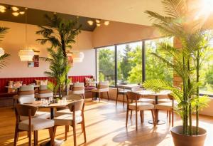 a restaurant with tables and chairs and plants at Cotswolds Hotel & Spa in Chipping Norton