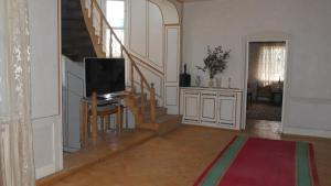 a living room with a television and a staircase at VillaStefania in Kʼarashamb