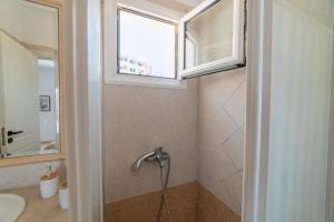 a bathroom with a shower with a sink and a window at AQUA KALMA in Myrties