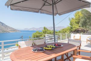 a wooden table with a bowl of fruit and an umbrella at AQUA KALMA in Myrties