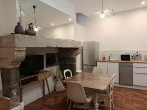 a kitchen and dining room with a table and a fireplace at Le relax max in Le Puy-en-Velay