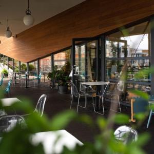 a restaurant with tables and chairs and windows at Hotel Termalny in Uniejow