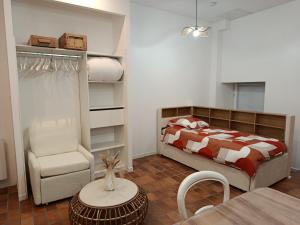 a bedroom with a bed and a chair and a table at Le relax max in Le Puy-en-Velay