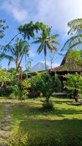 a resort with palm trees and a building at MAKCIK Heritage Villa & Cafe in Yogyakarta