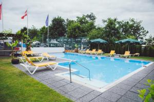 a swimming pool with chairs and umbrellas at Sporthotel Kurz in Oberpullendorf