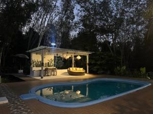 a swimming pool in a backyard with a gazebo at Phumaihom Resort in Hat Yai