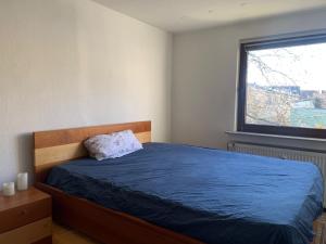 a bedroom with a blue bed and a window at Business Apartment Herne-Wanne in Herne