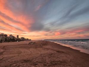 a beach with a cloudy sky and the ocean at Terraza Soleada in Puerto de Gandía