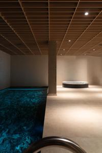 a room with a swimming pool with a table in the middle at At Hotel 35 in Słupca
