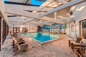 a large swimming pool with benches in a building at Landmark Holiday Beach in Panama City Beach