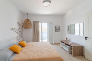a white bedroom with a large bed and a desk at AQUA KALMA in Myrties