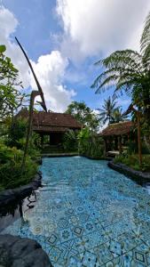 a swimming pool in front of a house at MAKCIK Heritage Villa & Cafe in Yogyakarta