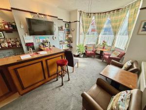 a living room with a tv and a couch and chairs at Maluth Lodge in Great Yarmouth