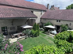 a courtyard of a house with benches and umbrellas at La Cour des Délices in Gigny