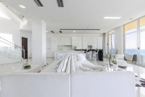 a white living room with a large white couch at Villa Belle Azure by PikHost in Dhërmi