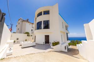 a white house with the ocean in the background at Villa Belle Azure by PikHost in Dhërmi