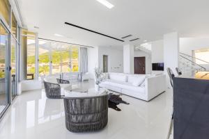 a living room with white furniture and large windows at Villa Belle Azure by PikHost in Dhërmi