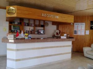 Eine Bar in einer Bibliothek mit einem Schild, auf dem „Rezeption“ steht. in der Unterkunft Dinara Apart Hotel in Kemer