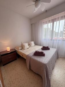a bedroom with a bed with two towels on it at Terraza Soleada in Puerto de Gandía +16 photos