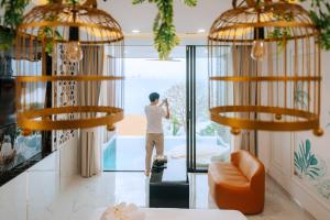 a man standing in a living room looking out at the ocean at Madusea Grand Villa มาดูซี แกรนด์ วิลล่า in Ko Larn +103 photos