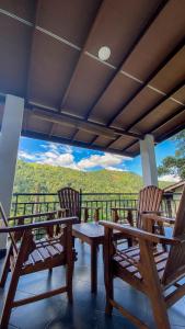 a porch with two chairs and a table with a view at Villa Mistora in Kandy