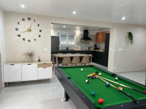a living room with a pool table and a clock at Maison cosy 6 pers Proche Europa-Park in Elsenheim