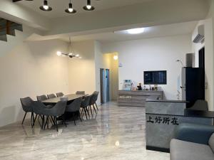 a dining room and living room with a table and chairs at 上好所在民宿 in Shoufeng