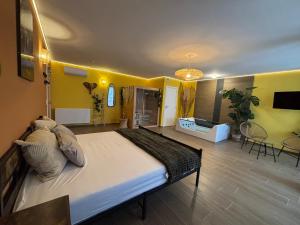 a large bed in a room with yellow walls at Le Bovary Hotel Suite Safari in Héron