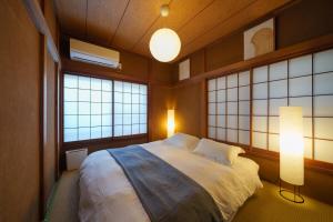 a bedroom with a large bed and two windows at Tachikawa City 3LDK Private House in Tachikawa