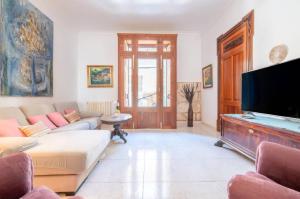 a living room with a couch and a flat screen tv at S'Arcada Mallorca in Sa Pobla