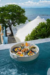 a pool with a tray of food in the water at Madusea Grand Villa มาดูซี แกรนด์ วิลล่า in Ko Larn