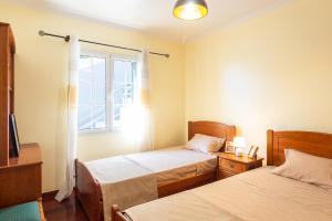 a bedroom with two beds and a window at Villa Lobos Flat 1 in Câmara de Lobos