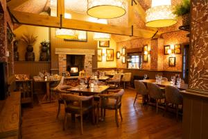 a restaurant with tables and chairs and a fireplace at Tollemache Arms in Calveley +28 photos