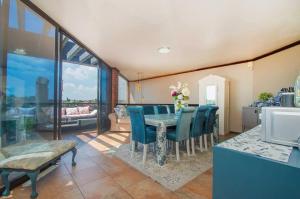 a dining room with a table and blue chairs at Manor on the Hill in Krugersdorp