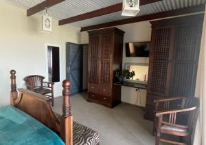 a bedroom with a bed and a desk and chairs at Moon Landscape Self Catering in Swakopmund
