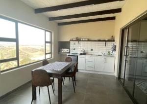 a kitchen with a table and some chairs in a room at Moon Landscape Self Catering in Swakopmund